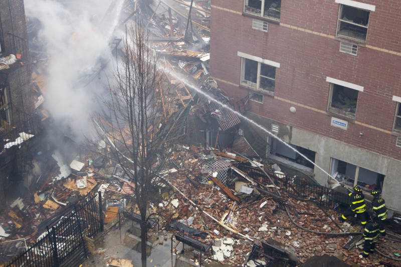 New York City firefighters hose down the rubble from a building that collapsed on Park Ave. and 116th Street in New York, March 12, 2014. (Gordon Donovan/Yahoo News)