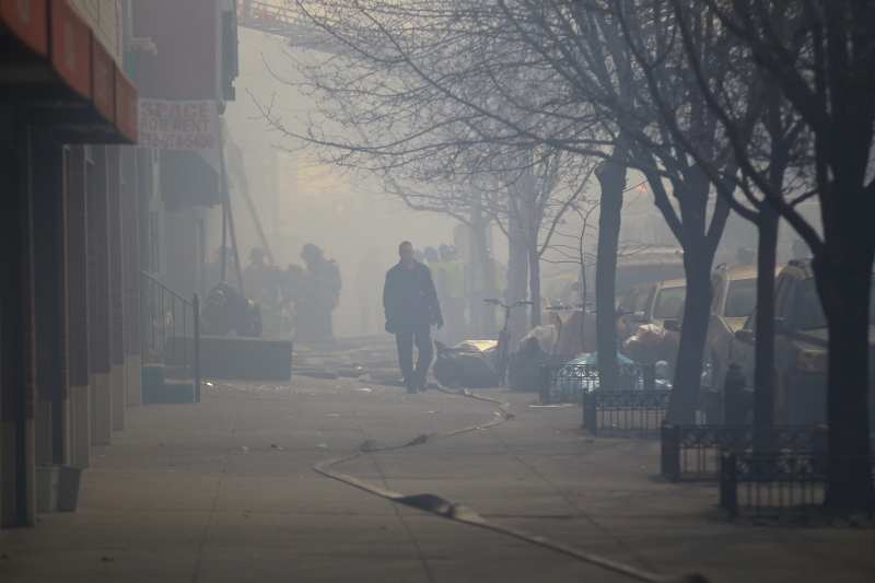 An emergency responder makes his through the smoke on 116th street in the Harlem section of New York City, after an explosion that took down two buildings March 12, 2014. (Gordon Donovan/Yahoo News)