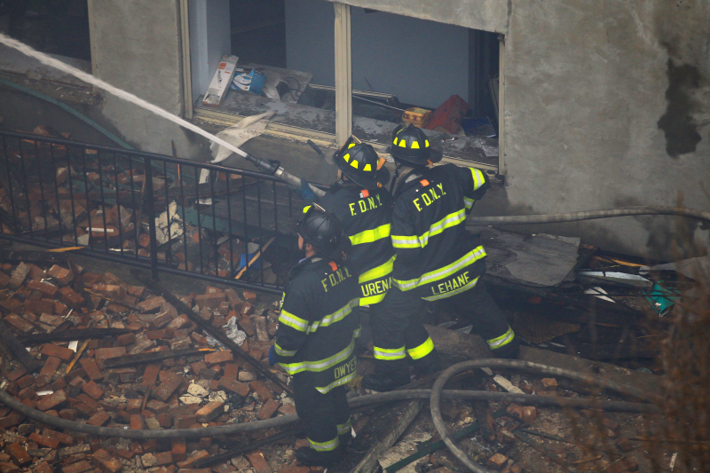New York City firefighters direct a hose towards the burning debris after two buildings collapsed on Park Ave. and 116th Street in New York City, March 12, 2014. (Gordon Donovan/Yahoo News)