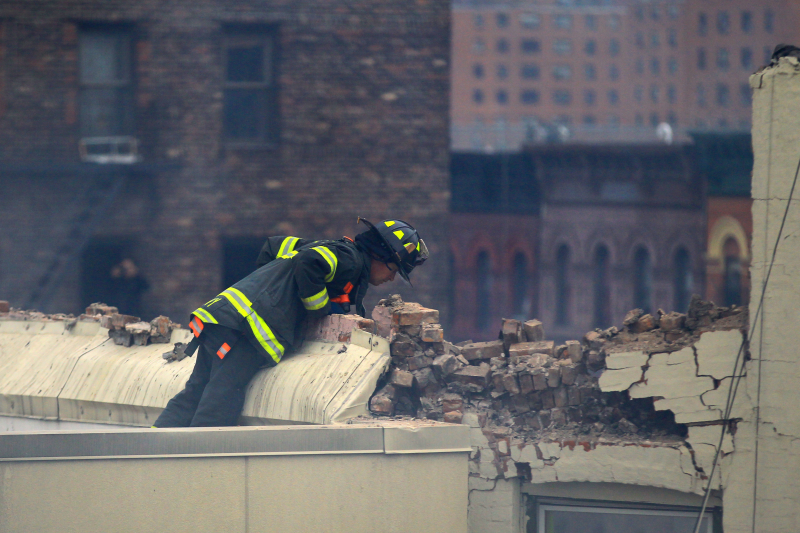 A New York City firefighter looks down on the remains of one of the building that collapsed and caught fire on Park Ave. and 116th Street in New York City, March 12, 2014. (Gordon Donovan/Yahoo News)