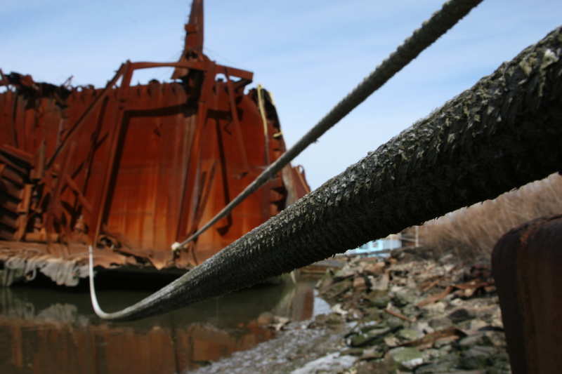 A line is tied to the remains of a partially scrapped service vessel in a scrap-metal yard. (Gordon Donovan)
