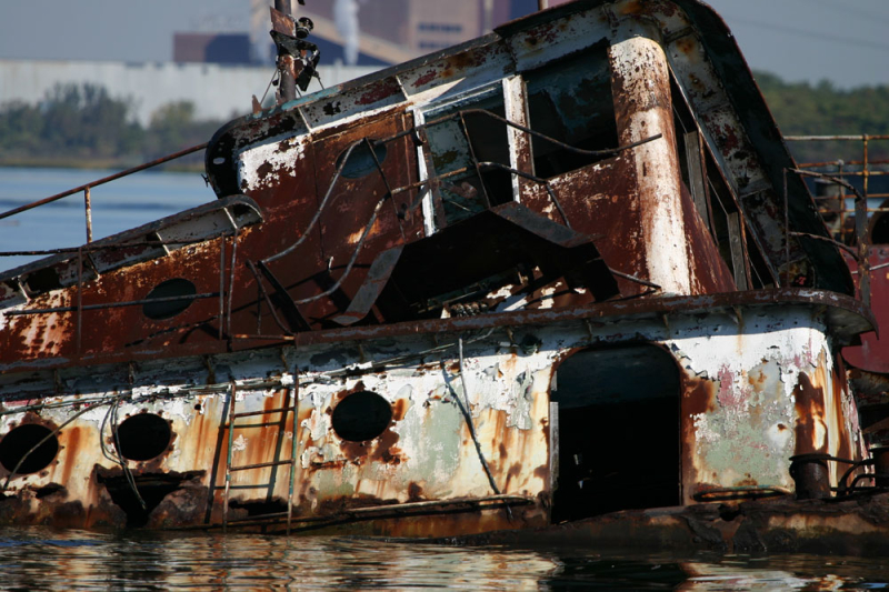The rusting and peeling paint of a retired service vessel in shallow waters of the Arthur Kill. (Gordon Donovan)