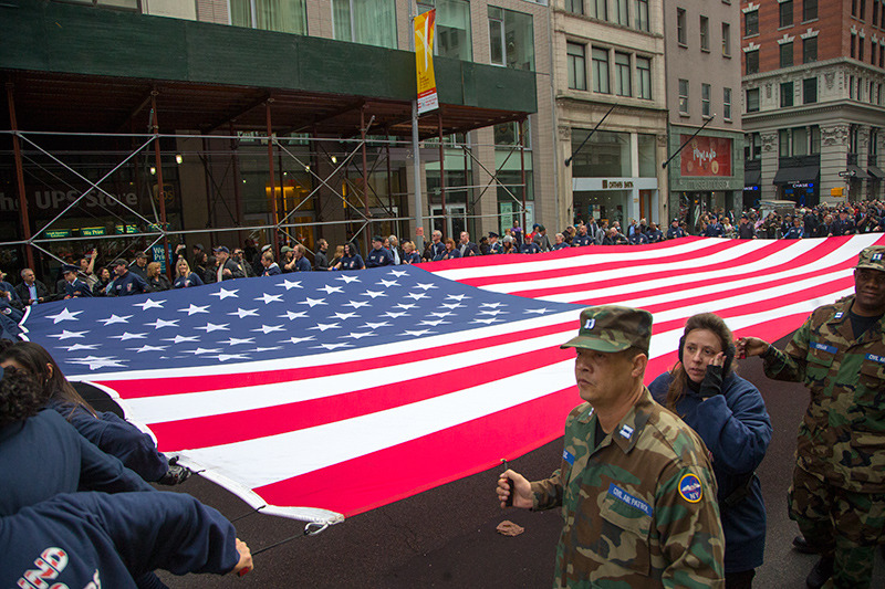An American flag is stretched across Fifth Avenue by veterans at the start of the Veterans Day parade in New York on Nov. 11, 2014. (Gordon Donovan)