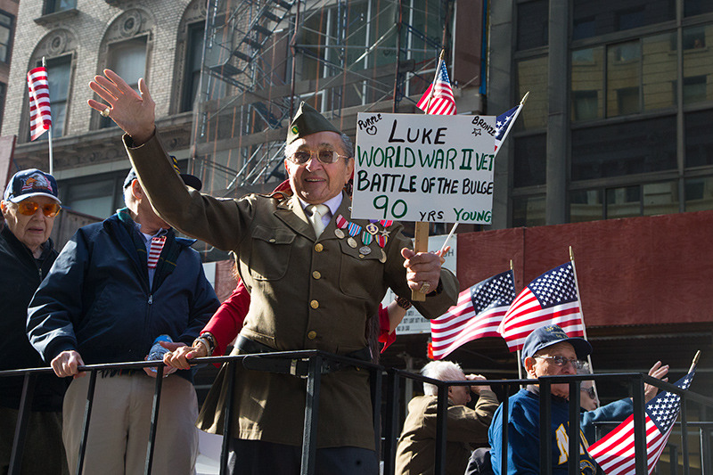 World War II veteran Luke Gaspare waves to the crowds aboard a float during the Veterans Day parade on Fifth Avenue in New York on Nov. 11, 2014. (Gordon Donovan) 