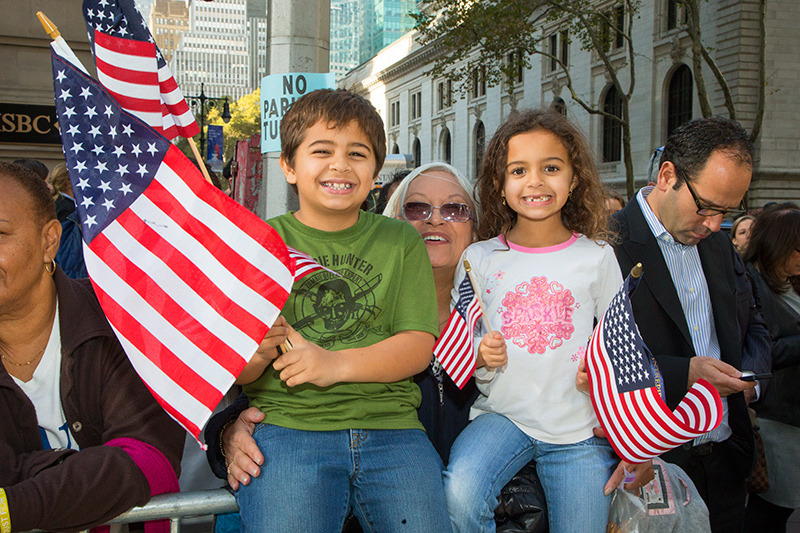 Children wave flags to acknowledge veterans marching during the Veterans Day parade on Fifth Avenue in New York on Nov. 11, 2014. (Gordon Donovan) 