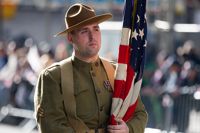 A flag bearer dressed as a doughboy (WWI infantryman) pauses during the Veterans Day parade on Fifth Avenue in New York on Nov. 11, 2014.. (Gordon Donovan) 