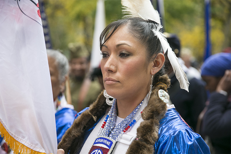 A woman in Native American garb gets ready for the parade. (Gordon Donovan)