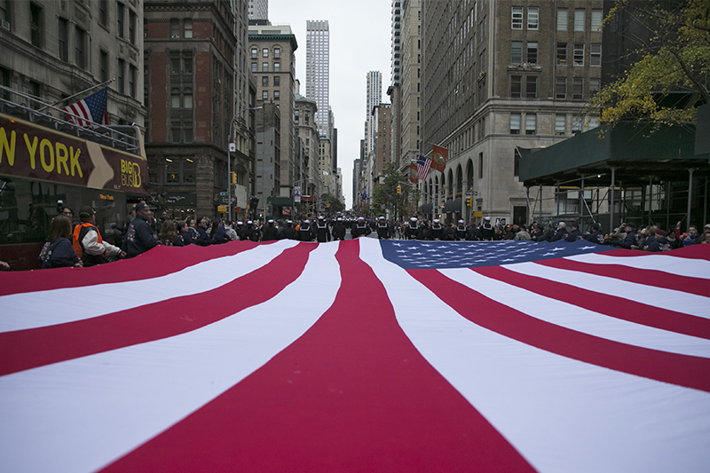 An American flag is draped across Fifth Avenue during the Veterans Day parade in New York on Nov. 11, 2015. (Gordon Donovan)