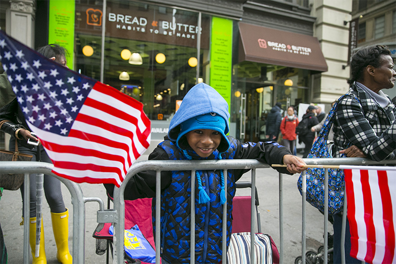 A spectator is all smiles and cheers as vets march during the Veterans Day parade on Fifth Avenue in New York on Nov. 11, 2015. (Gordon Donovan)