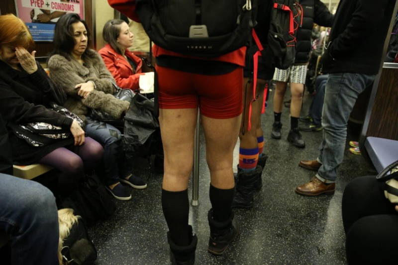 Passengers try to block out people take art taking part in the No Pants Subway Ride in New York City, Sunday, Jan. 10, 2016. The 'No Pants Subway Ride' is an annual event that has become a global celebration of bare thighs. The 'celebration of silliness' is designed to make other subway riders smile. (Gordon Donovan/Yahoo News)