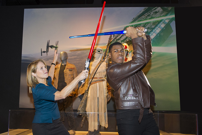 Yahoo Global News Anchor Katie Couric summons the force as she battles actor John Boyega with light sabers at the “Star Wars and the Power of Costume” exhibition at Discovery Times Square in New York City on Dec. 2, 2015. Boyega stars as Finn in “Star Wars: The Force Awakens.” (Gordon Donovan/Yahoo News)