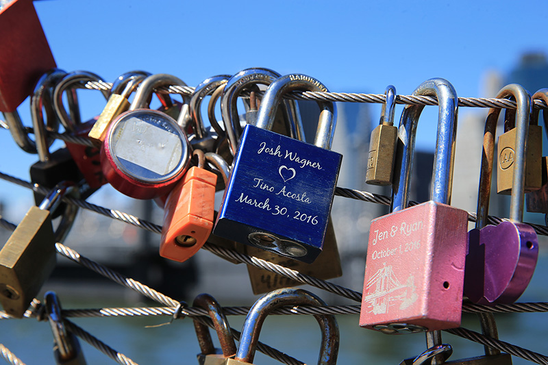 Visitors have been attaching locks with sentimental messages to railings like these on the Brooklyn waterfront as symbolic acts of affection. (Gordon Donovan/Yahoo News)