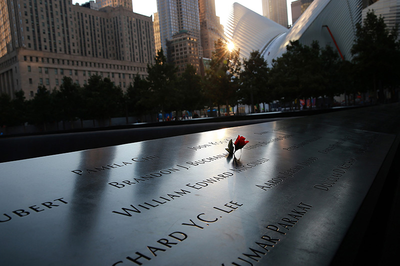 Flowers are laid on the panels of the names of victims from the September 11, 2001 attacks are reflected by the morning light on Sept. 8, 2016.(Gordon Donovan/Yahoo News)