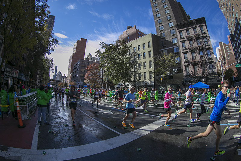 Runners step on used water cups discarded on the street during the 2016 New York City Marathon, Nov. 6, 2016. (Gordon Donovan/Yahoo News)