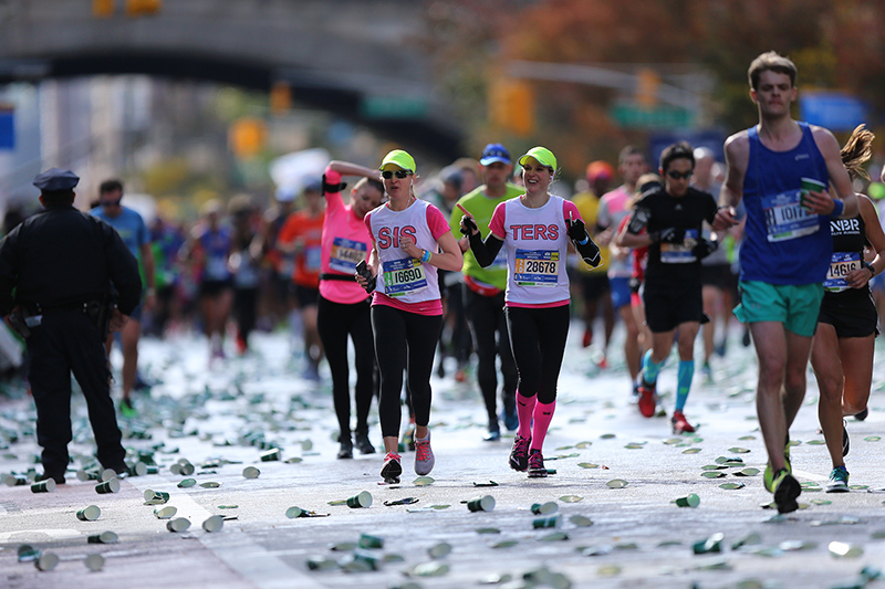 Two sisters run together up First Ave. just past mile 16 of the 2016 New York City Marathon, Nov. 6, 2016. (Gordon Donovan/Yahoo News)