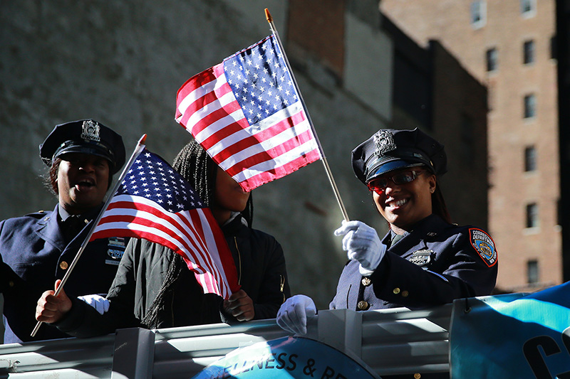 Police officers wave flags on a float during the Veterans Day parade on Fifth Avenue in New York City on Nov. 11, 2016. (Gordon Donovan/Yahoo News)