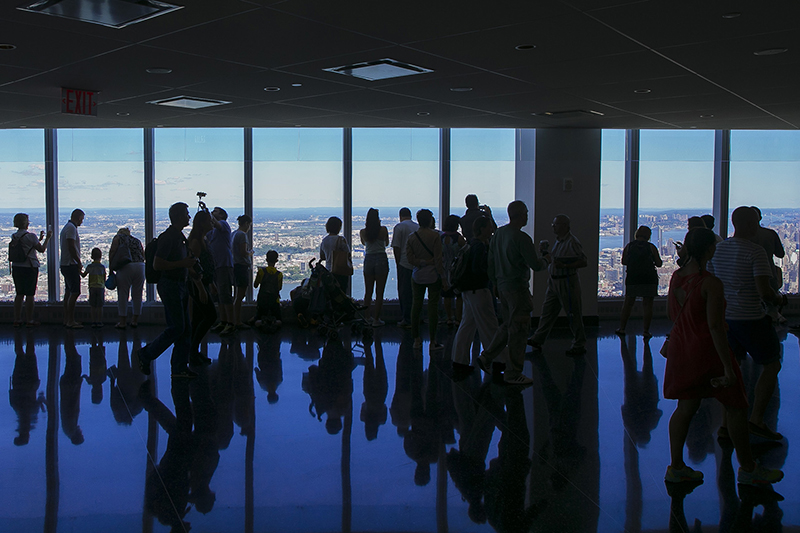 Visitors are reflected in the floor as they photograph the amazing views from observatory on the 100th floor of One World Trade Center in New York City on Tuesday, Aug 23, 2016. (GordonDonovan/Yahoo News)