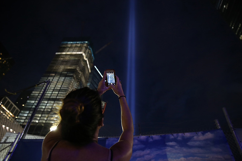 A woman takes a photo of the Tribute in Light with her mobile device at the National September 11 Memorial & Museum on Sept. 10, 2016. (Gordon Donovan/Yahoo News)