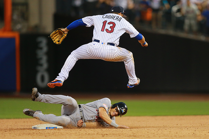 New York Mets shortstop Asdrubal Cabrera (13) goes airborne over Miami Marlins Derek Dietrich (32) for the double play in the ninth inning at Citi Field in New York, Monday, July 4, 2016. The Mets won 8-6. (Gordon Donovan)