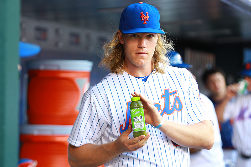 New York Mets All-Star pitcher Noah Syndergaard shows off his marketing skills as he displays a bottle of Doctor Earth Raw Juice Blend before the start of the baseball game against the Miami Marlins at Citi Field in New York, Tuesday, July 5, 2016. (Gordon Donovan)