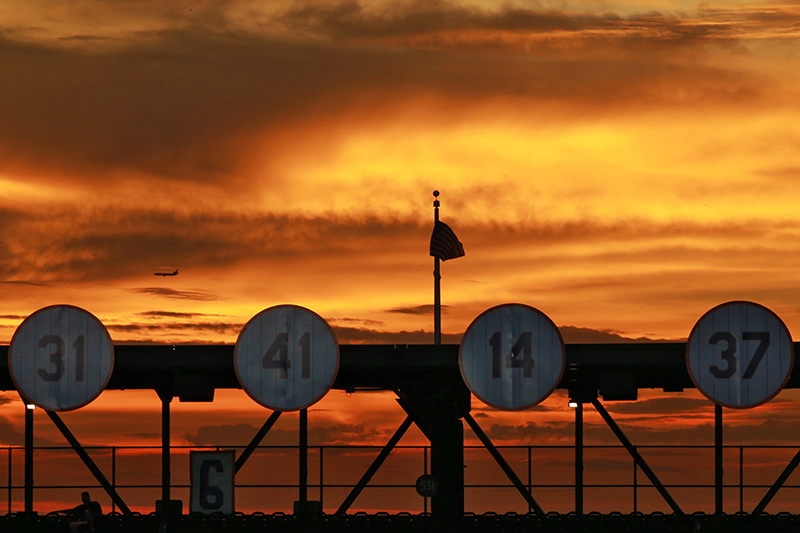 A plane flies by after take off from La Guardia Airport as the sun begins to set just beyond the retired numbers at Citi Field in New York, Aug. 12, 2016. (Gordon Donovan)