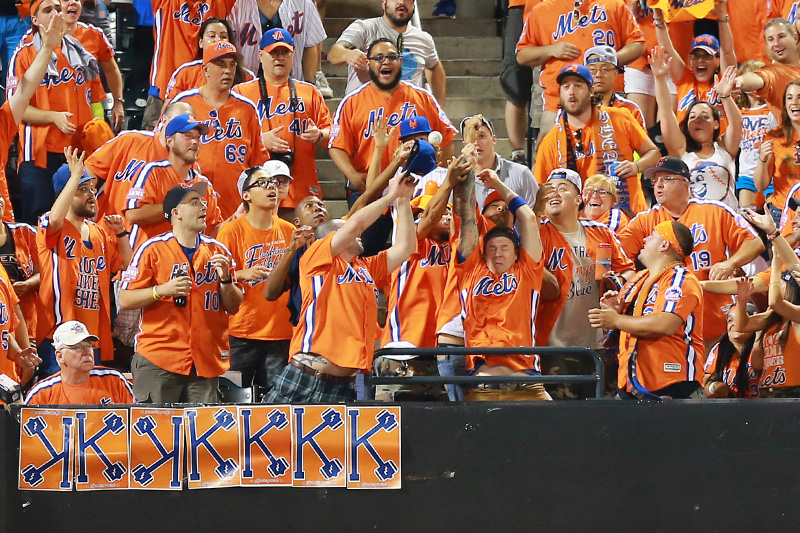 New York Mets fans attempt to catch Kelly Johnson's home run in the seventh inning of a baseball game against the Philadelphia Phillies at Citi Field in New York, Saturday, Aug. 27, 2016. (Gordon Donovan)