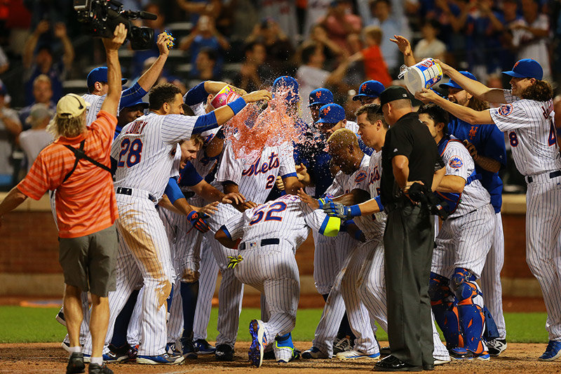 New York Mets Yoenis Cespedes is greeted at home plate by teammates after his home run with two outs in the bottom of the 10th inning to give the Mets a 2-1 victory against the Miami Marlins at Citi Field in New York, August 29, 2016. (Gordon Donovan)
