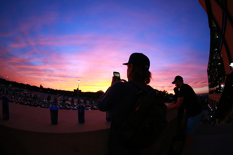 A fan uses his mobile device to take a photo the sunset on the left field stairs at Citi Field during the baseball game between the Washington Nationals and New York Mets on Friday, Sept. 2, 2016. (Gordon Donovan)