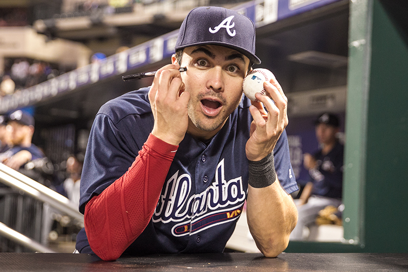 Atlanta Braves Chase d'Arnaud enjoys a moment with the photographers while signing for a fan before the baseball game against the New York Mets at Citi Field in New York, Tuesday, September 20, 2016. (Gordon Donovan)