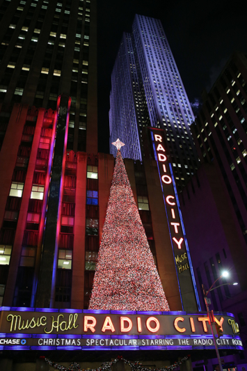 The Christmas tree made of lights stands on the marquee of Radio City Music Hall in New York City with Rockefeller Center illuminating in the background. (Gordon Donovan/Yahoo News)