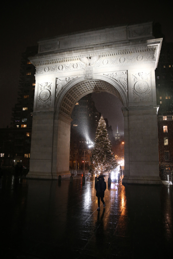 A woman walks in the snow past the Christmas tree inside the Washington Square Arch in New York City. (Gordon Donovan/Yahoo News)