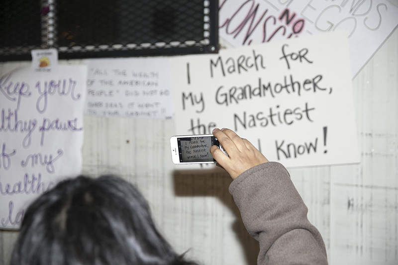 People examine discarded signs from Women's March in New York City on Jan. 21, 2017. (Gordon Donovan/Yahoo News)