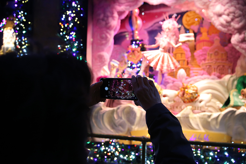 A visitor takes a photo of the window display with her mobile device outside of Saks Fifth Avenue in New York City. (Gordon Donovan/Yahoo News)