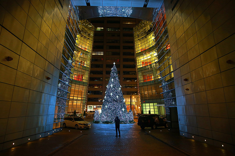 A person takes a photo of the Christmas tree at the Bloomberg Tower in New York City. (Gordon Donovan/Yahoo News)