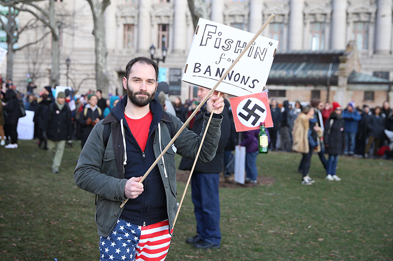 A man holds up anti-Trump signs before a march in New York's Battery Park in New York, Jan. 29, 2017, protesting President Donald Trump's immigration order. (Gordon Donovan/Yahoo News)