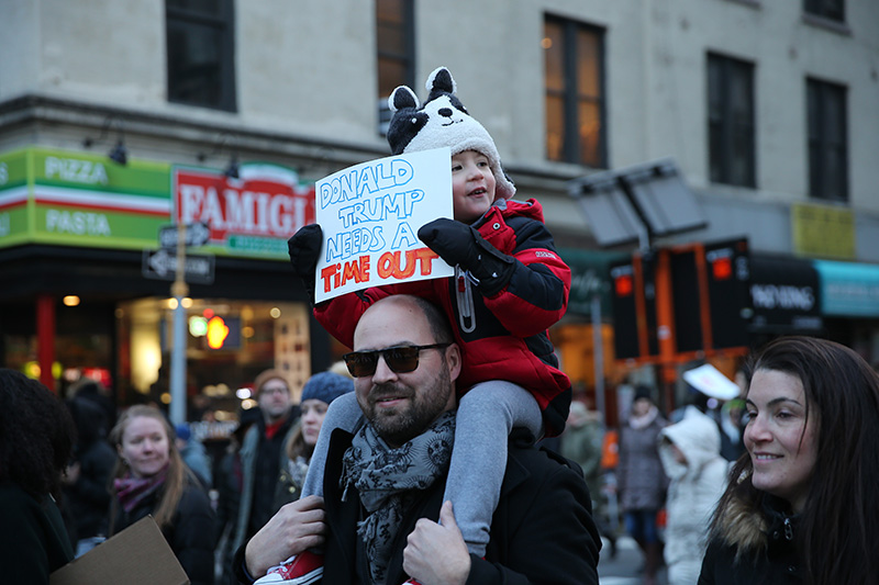 A youngster rides dad's shoulders and holds up a sign during a march in New York, Jan. 29, 2017, protesting President Donald Trump's immigration order. (Gordon Donovan/Yahoo News)
