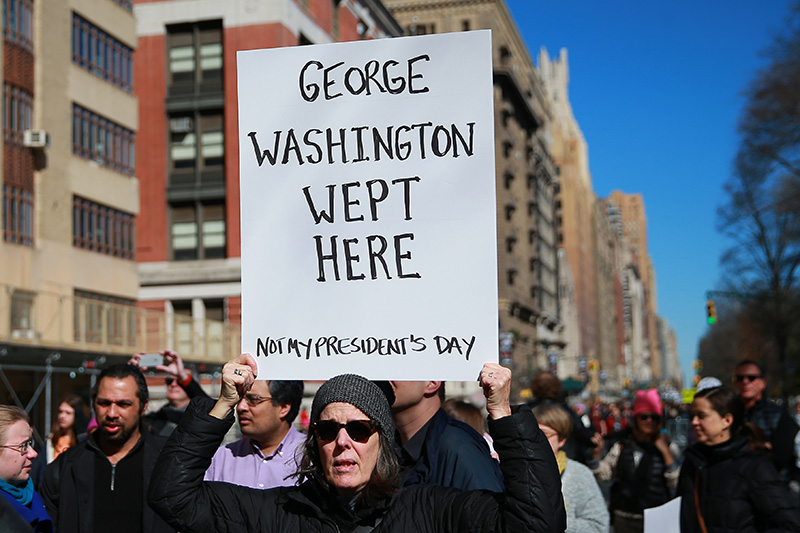 A demonstrator holds up a sign during the “Not My President’s Day” rally at Central Park West in New York City on Feb. 20, 2017. (Gordon Donovan/Yahoo News)