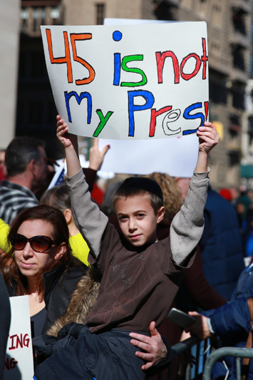 A youngster with his mother holds up a sign during the “Not My President’s Day” rally at Central Park West in New York City on Feb. 20, 2017. (Gordon Donovan/Yahoo News)