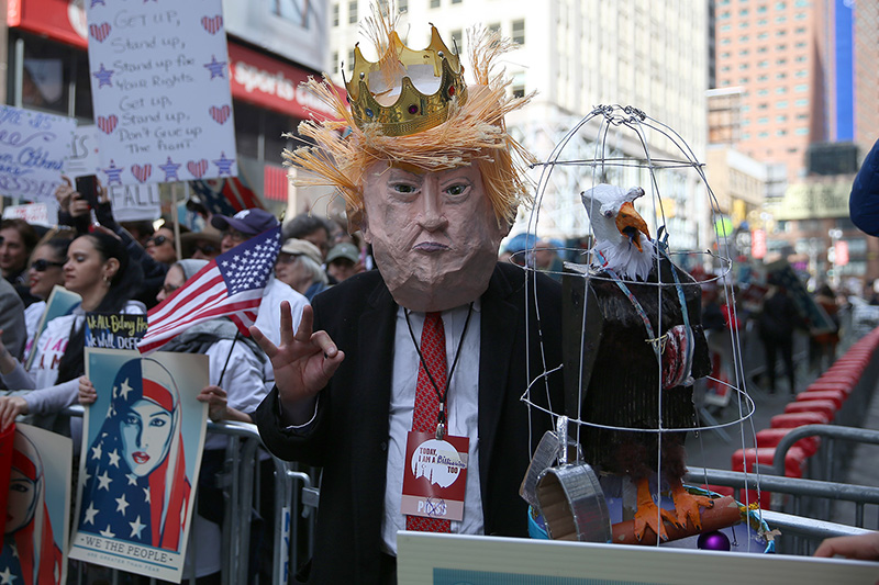 A protester wears a mask of U.S. President Donald Trump at the “I am a Muslim too" rally at Times Square in New York City on Feb. 19, 2017. (Gordon Donovan/Yahoo News)