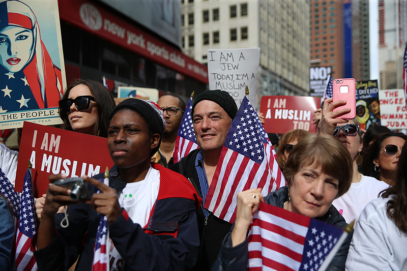 Participants hold signs and flags at the “I am a Muslim too" rally at Times Square in New York City on Feb. 19, 2017. (Gordon Donovan/Yahoo News)