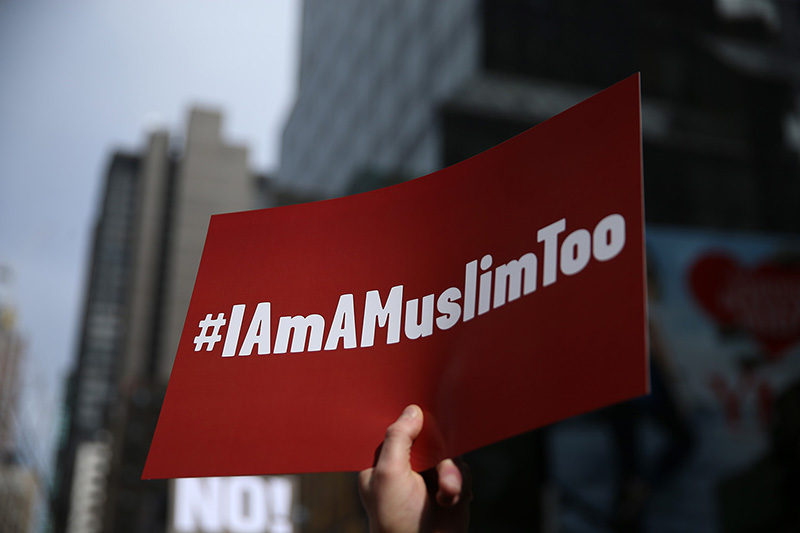 A protester holds up signs at the “I am a Muslim too" rally at Times Square in New York City on Feb. 19, 2017. (Gordon Donovan/Yahoo News)