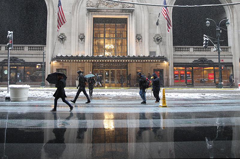 The reflections of people off the wet sidewalk as they pass the MetLife Building in New York City during a winter storm on Feb. 9, 2017. (Gordon Donovan/Yahoo News)