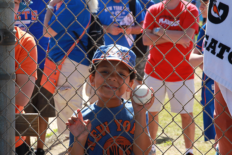 A young fan stands behind a fence looking for an autograph from a player during morning workouts at the New York Mets spring training facility in Port St. Lucie, Fl., Sunday, Feb. 26, 2017. (Gordon Donovan/Yahoo Sports)